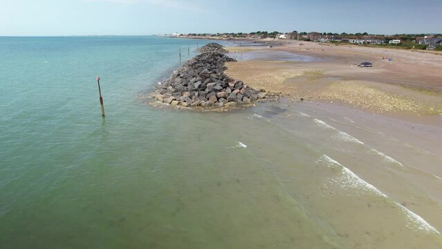 People Swims At Elmer Sands Beach With Sea Defences Near Bognor Regis, West Sussex, UK. Aerial Pullback