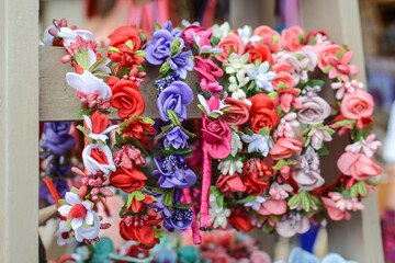 wreath on the head with their own hands. many headbands decorated with artificial flowers for sale in the bazaar