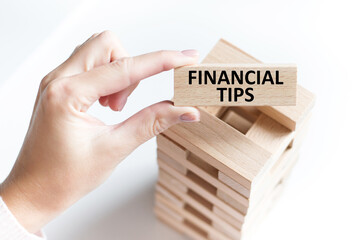 FINANCIAL TIPS word on a dynamic blonde in the hands of a person on a light background