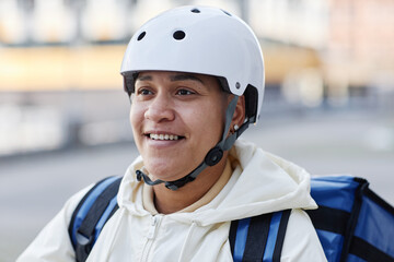 Fototapeta na wymiar Close up portrait of smiling woman working in food delivery service city setting
