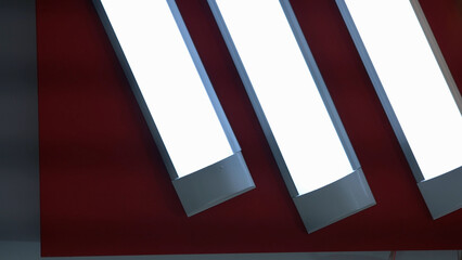 Horizontal long lamps on the red ceiling. Room illumination technology.