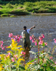 Angler beim Fliegenfischen an einem idyllischen Fluss 