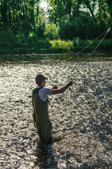 Angler beim Fliegenfischen an einem idyllischen Fluss 