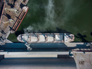 Aerial view of big cargo ship bulk carrier is loaded with minerals in port