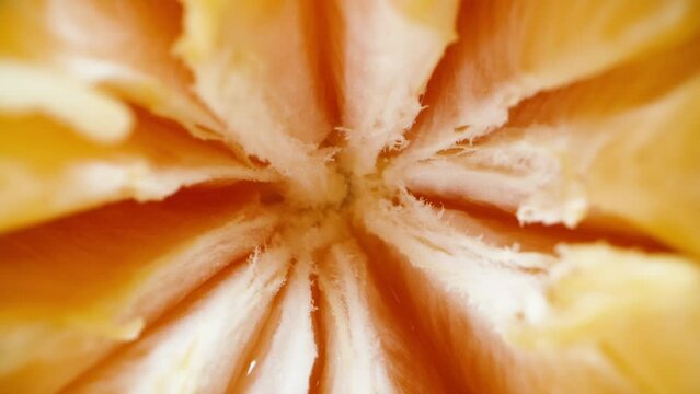 The top view. super macro. The tangerine divided into slices rotates on a black background. Dolly slider