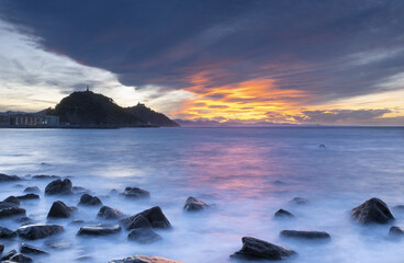 Naklejka premium Red clouds at sunset on the coast of Donostia-San Sebastian, Euskadi