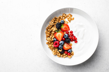 Fototapeta na wymiar Oatmeal or granola with greek yogurt and fresh berries, view from above