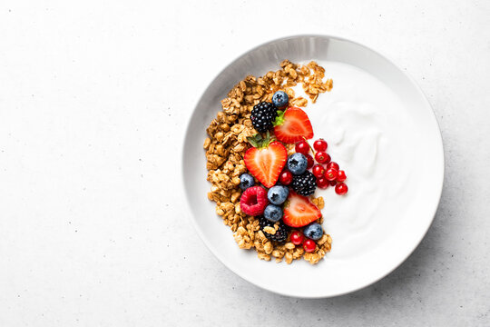 Oatmeal or granola with greek yogurt and  fresh berries, view from above