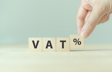 VAT concept. Value Added Tax. VAT text on wooden cubes with grey background.