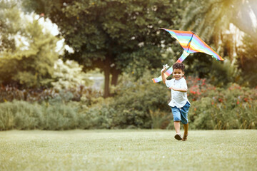 Child, kite and grass while running for wind to lift, air and sky while play, fun and happy...