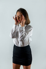 Beautiful young brunette suffering from headache on white isolated background.