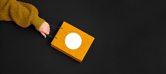 Female hands holding gift kraft bag. woman running to get the latest offers. Concept of black Friday sales, Christmas shopping