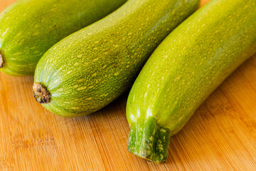 bunch of zucchini close up on wooden board