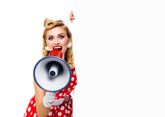 Portrait image of beautiful woman holding megaphone, shout advertising something. Girl in red pin...