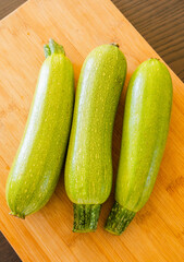bunch of zucchini close up on wooden board