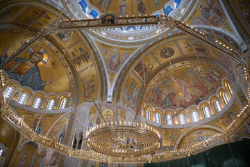Naklejka premium Interiors of St. Sava's Church in Belgrade with religious paintings and mosaics on the luxuriously gold decorated walls. Belgrade, Serbia 22.09.2022