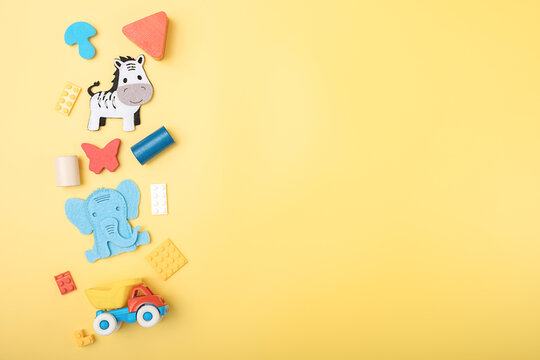 Bright Multi Colored Kids Toys, Details Of A Plastic Constructor, Frame On Yellow Background. Top View. Flatlay. Copy Space For Text.