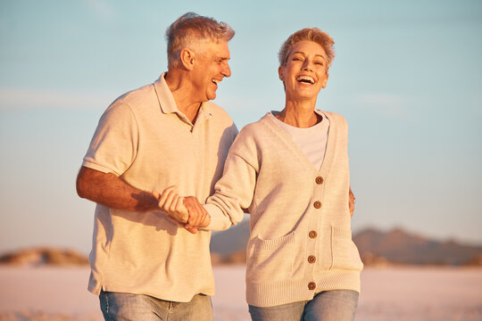 Retirement, couple and being playful outdoor, walking or on beach being loving, together or happy marriage. Love, senior man and mature woman with smile, embrace and holding hands and seaside bonding