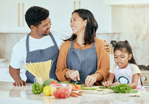 Cooking, Kitchen And Family With A Girl, Mother And Father Preparing Food For A Meal In Their Home Together. Children, Health And Diet With A Man, Woman And Daughter Making Dinner In A House