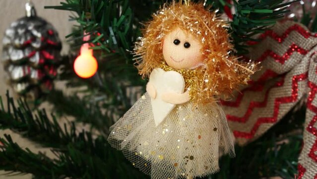 Close-up of a beautiful ragdoll fairy hanging on a Christmas tree branch