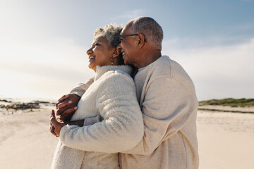 Obraz premium Senior couple enjoying a view of the ocean at the beach