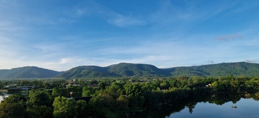 Fototapeta na wymiar The beautiful natural scenery of lakes, trees, mountains, clouds and sky is a summer travel in Asia. with a landscape and a peaceful and shady environment