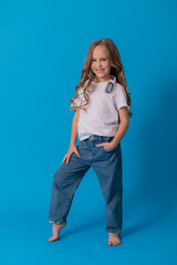 blonde girl in jeans and a white T-shirt listens to music with headphones and dances