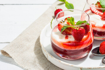 Italian dessert panna cotta in glass with strawberries. Healthy sweet food, hard light, dark shadow