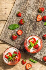 Italian dessert panna cotta in glass with strawberries. Healthy sweet food, hard light, dark shadow