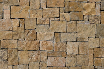 Fondo con detalle y textura de superficie de muro rustico de piedras en diferentes tonos marrones