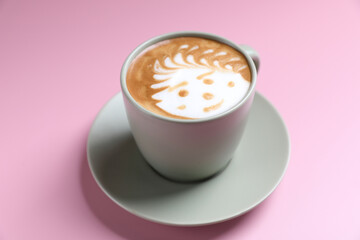 hot cappuccino with latte art isolated in pink background
