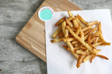 Homemade French fries on rustic wooden table