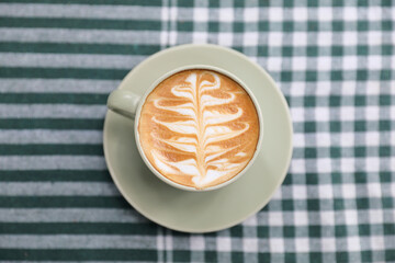 hot cappuccino with latte art on wood background