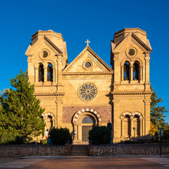 Obraz premium The facade of Cathedral Basilica of St. Francis of Assisi illuminated by the sun rays in Santa Fe, the capital of New Mexico