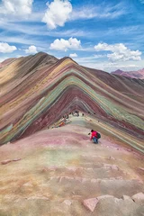 Papier Peint photo autocollant Vinicunca Tourist climbs in the foreground of the Rainbow Mountains at an altitude of 5000 meters.