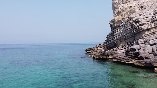 Drone shot of rocky cliff on the sea in Oman