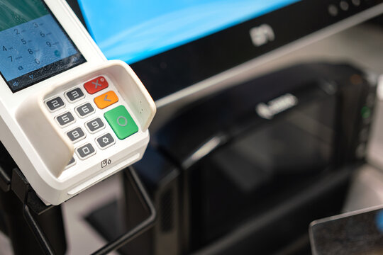 A credit card reader machine at the payment cashier. Financial technology device object photo, selective focus on the number keypad.