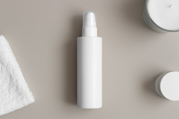 White cosmetic lotion bottle mockup with a towel on the beige table.