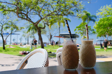 Coffee cups on a table at beautiful sunny day in Cairns city esplanade - obrazy, fototapety, plakaty