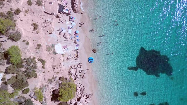 Swimmers crystal clear water, algae, seaweed.
Spectacular aerial view flight vertical 9:16 bird's eye view drone
of Ibiza cala Salada Saladeta beach at summer 2022. 4k marnitz Cinematic