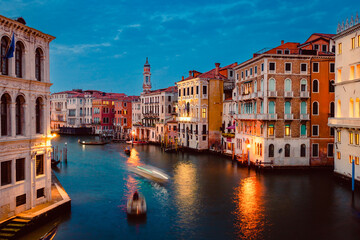 Obraz premium View of Venice's Grand Canal at sunset with illuminated historic buildings and light trails of tourist boats