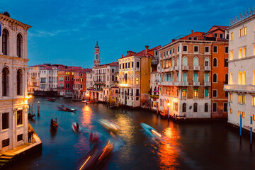 Obraz na płótnie Canvas View of Venice's Grand Canal at sunset with illuminated historic buildings and light trails of tourist boats