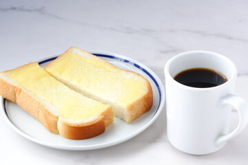 Fototapeta na wymiar マーガリンを塗ったパンとコーヒーの朝食