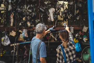 mechanic technician team wearing uniform reading or writing clipboard document and standing in auto repair shop garage, with car vehicle background, job of auto garage service concept