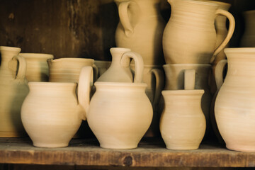 Ceramic clay jugs standing on a shelf in the village