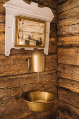 Obraz na płótnie Canvas Vintage shot of an old metal washbasin and mirror in a wooden house in the village
