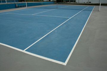 blue tennis court with its lines and net set