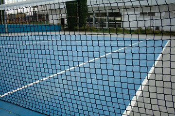 blue tennis court with its lines and net set