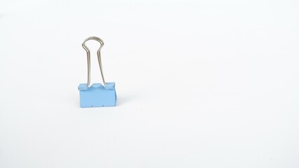 A binder clip is a strip of spring steel bent into the shape of an isosceles triangle with loops at the apex. This tool is used to clamp paper to make it neater
