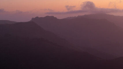 Foggy layer of mountains at sunrise time.